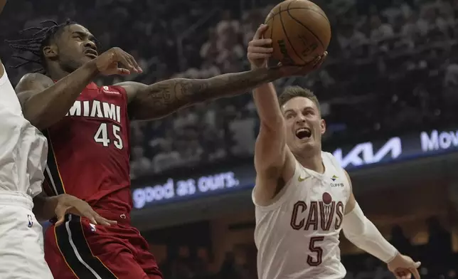 Cleveland Cavaliers guard Sam Merrill (5) knocks the ball away from Miami Heat guard Davion Mitchell (45) in the first half in Game 1 of an NBA first-round playoff series, Sunday, April 20, 2025, in Cleveland. (AP Photo/Sue Ogrocki)