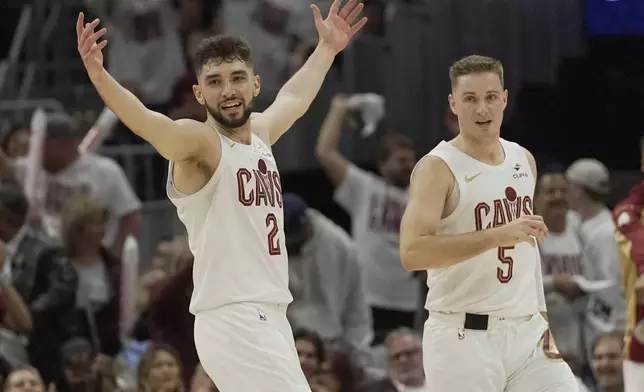 Cleveland Cavaliers guard Ty Jerome (2) celebrates in front of teammate Sam Merrill in the second half in Game 1 of an NBA first-round playoff series against the Miami Heat, Sunday, April 20, 2025, in Cleveland. (AP Photo/Sue Ogrocki)