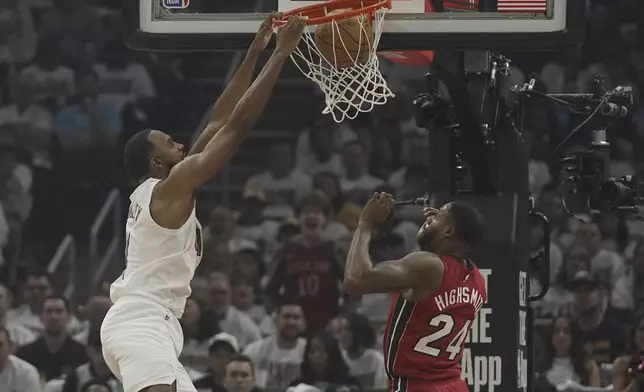 Cleveland Cavaliers forward Evan Mobley (4) left, dunks over Miami Heat forward Haywood Highsmith (24) in the first half in Game 1 of an NBA first-round playoff series, Sunday, April 20, 2025, in Cleveland. (AP Photo/Sue Ogrocki)