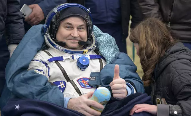 Roscosmos cosmonaut Alexey Ovchinin gestures as he sits outside after landing in a Soyuz MS-26 spacecraft with fellow cosmonaut Ivan Vagner and NASA astronaut Don Pettit in a remote area near the town of Zhezkazgan, Kazakhstan, Sunday, April 20, 2025. (Bill Ingalls/NASA via AP)