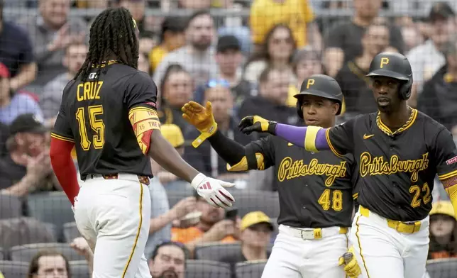 Pittsburgh Pirates' Oneil Cruz (15) is greeted by Enmanuel Valdez (48) and Andrew McCutchen (22) after scoring during the third inning of a baseball game against the Washington Nationals, Monday, April 14, 2025, in Pittsburgh. (AP Photo/Matt Freed)