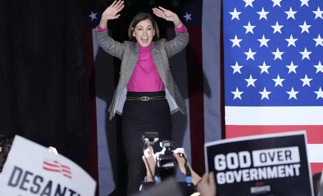 FILE - Iowa Gov. Kim Reynolds arrives on stage with Republican presidential candidate Florida Gov. Ron DeSantis before he speaks to supporters during a caucus night party, Jan. 15, 2024, in West Des Moines, Iowa. (AP Photo/Charlie Neibergall, File)