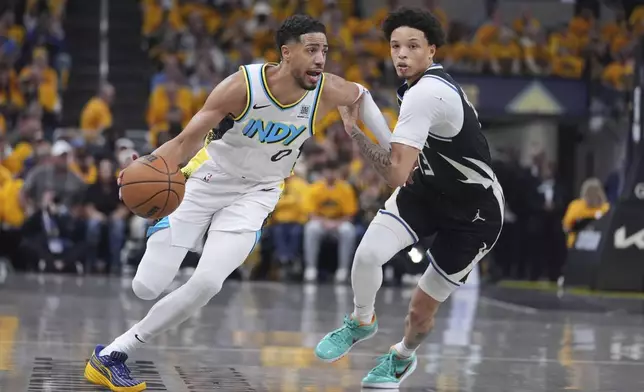 Indiana Pacers' Tyrese Haliburton (0) drives past Milwaukee Bucks' Ryan Rollins during the first half of a first-round NBA basketball playoff game, Saturday, April 19, 2025, in Indianapolis. (AP Photo/Michael Conroy)