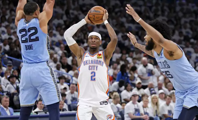 Oklahoma City Thunder guard Shai Gilgeous-Alexander (2) looks to pass between Memphis Grizzlies guard Desmond Bane (22) and forward Marvin Bagley III, right, during the first half in Game 1 of an NBA first-round playoff series, Sunday, April 20, 2025, in Oklahoma City. (AP Photo/Nate Billings)
