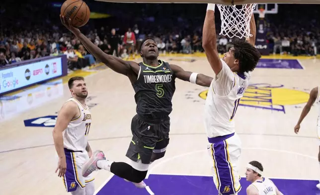 Minnesota Timberwolves guard Anthony Edwards, center, shoots as Los Angeles Lakers center Jaxson Hayes, right, and guard Luka Doncic defend during the first half in Game 1 of an NBA first-round playoff series Saturday, April 19, 2025, in Los Angeles. (AP Photo/Mark J. Terrill)
