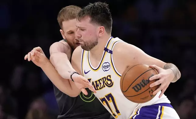Los Angeles Lakers guard Luka Doncic, right, dries toward the basket as Minnesota Timberwolves guard Donte DiVincenzo defends during the second half in Game 1 of an NBA first-round playoff series Saturday, April 19, 2025, in Los Angeles. (AP Photo/Mark J. Terrill)