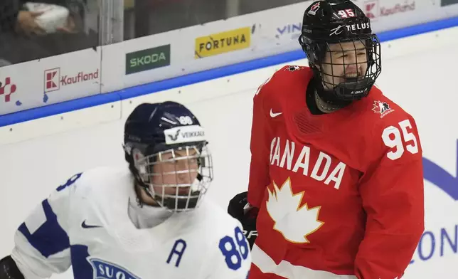 Finland's Ronja Savolainen, left, skates past as Daryl Watts of Canada celebrates after scoring her sides third goal during the semi final match between Canada and Finland at the Women's Ice Hockey Championships in Ceske Budejovice, Czech Republic, Saturday, April 19, 2025. (AP Photo/Petr David Josek)