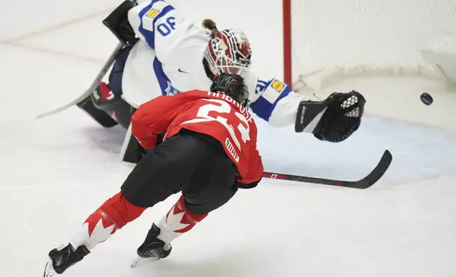Erin Ambrose of Canada, right, scores her sides first goal past Finland's Emilia Kyrkko during the semi final match between Canada and Finland at the Women's Ice Hockey Championships in Ceske Budejovice, Czech Republic, Saturday, April 19, 2025. (AP Photo/Petr David Josek)