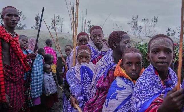 Maasai children line up during the Enkipaata ceremony, a Maasai male rite of passage, specifically the initiation of boys, marking the transition from childhood to becoming a moran (warrior) in Olaimutiai, Narok County, Kenya Wednesday, April 23, 2024. (AP Photo/Brian Inganga)