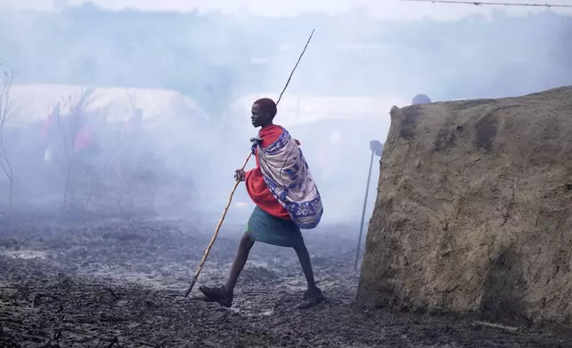 A Maasai child walk around a manyatta (traditional Maasai homestead) during the Enkipaata ceremony, a Maasai male rite of passage, specifically the initiation of boys, marking the transition from childhood to becoming a moran (warrior) in Olaimutiai, Narok County, Kenya Thursday, April 24, 2024. (AP Photo/Brian Inganga)