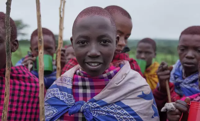 Isaac Mpusia, 16 years old, of the Maasai tribe poses for a photo, during the Enkipaata ceremony, a Maasai male rite of passage, specifically the initiation of boys, marking the transition from childhood to becoming a moran (warrior) in Olaimutiai, Narok County, Kenya Thursday, April 24, 2024. (AP Photo/Brian Inganga)