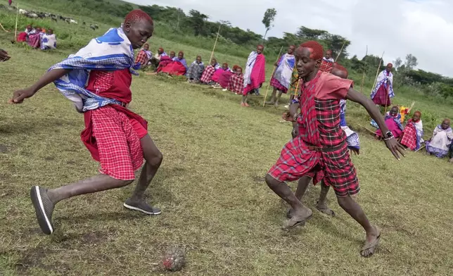 Children of the Maasai tribe play football in an open field, during the Enkipaata ceremony, a Maasai male rite of passage, specifically the initiation of boys, marking the transition from childhood to becoming a moran (warrior) in Olaimutiai, Narok County, Kenya Thursday, April 24, 2024. (AP Photo/Brian Inganga)