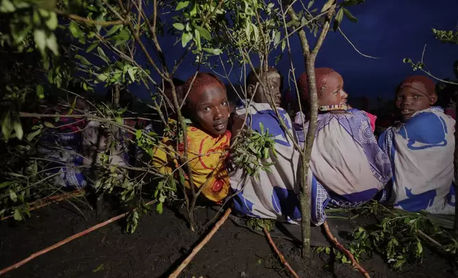 Children of the Maasai tribe sit down in a circle, during the Enkipaata ceremony, a Maasai male rite of passage, specifically the initiation of boys, marking the transition from childhood to becoming a moran (warrior) in Olaimutiai, Narok County, Kenya Wednesday, April 23, 2024. (AP Photo/Brian Inganga)