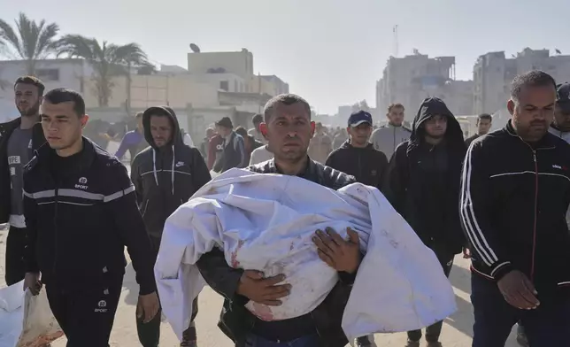 Mohammad Al-Qadi carrying body of his nephew who was killed in an Israeli army airstrike, during his funeral in Khan Younis, southern Gaza Strip, Saturday, April 19, 2025. (AP Photo/Abdel Kareem Hana)