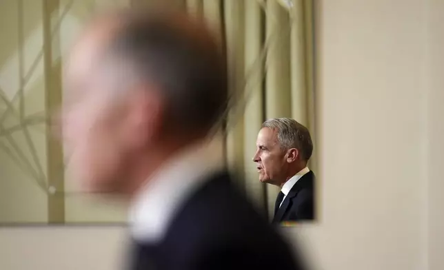 FILE - Canada's Prime Minister Mark Carney, reflected in a mirror, speaks to media during a press conference at Canada House in London on March 17, 2025. (Sean Kilpatrick/The Canadian Press via AP, File)