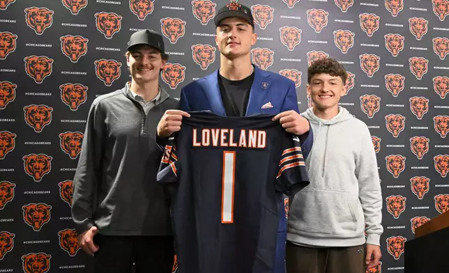 Tight end Colston Loveland, the Chicago Bears' first round draft pick, 10th overall, shows off his jersey with brothers' Cayden Loveland, left, and Cash Loveland, during an NFL football press conference, Friday, April 25, 2025, in Lake Forest, Ill. (AP Photo/Matt Marton)