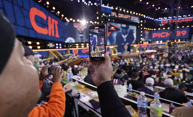 A fan takes video during a pick by the Chicago Bears during the second round of the NFL football draft, Friday, April 25, 2025, in Green Bay, Wis. (AP Photo/Matt Ludtke)
