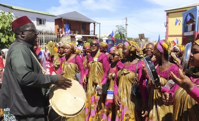 A group of singers and dancers perform after French President Emmanuel Macron's visit Monday, April 21, 2025 in Tsingoni , Mayotte island, in the Indian Ocean French territory of Mayotte. (AP Photo/Alexis Duclos)