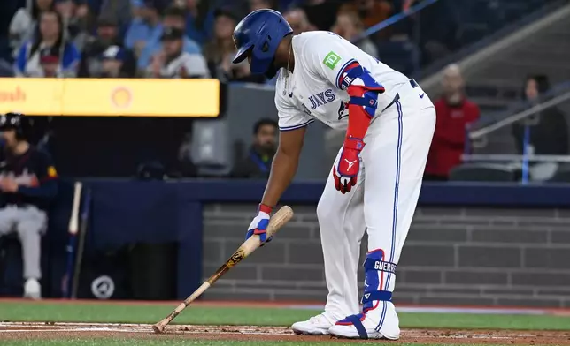 Toronto Blue Jays first baseman Vladimir Guerrero Jr (27) writes in the dirt before an at bat against the Atlanta Braves in the first inning of an interleague baseball game in Toronto, Wednesday, April 16, 2025. (Jon Blacker/The Canadian Press via AP)