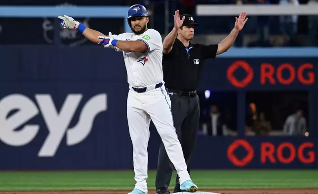 Toronto Blue Jays left fielder Anthony Santander (25) gestures to the dugout after hitting a double against the Atlanta Braves batter in the first inning of an interleague baseball game in Toronto, Wednesday, April 16, 2025. (Jon Blacker/The Canadian Press via AP)