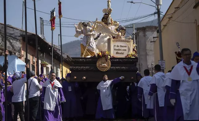 Faithful carry a platform with a statue of Jesus of Nazareth, wearing a tunic created by weavers at the Maria Auxiliadora embroidery workshop, during a Lenten season procession in Antigua, Guatemala, Sunday, April 6, 2025. (AP Photo/Santiago Billy)