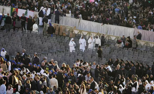 Nuns and other pilgrims look for their seats in St. Peter's Square ahead of the funeral of Pope Francis, at the Vatican, Saturday, April 26, 2025. (AP Photo/Markus Schreiber)