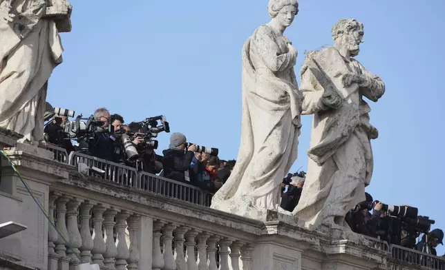 Journalists stand on the colonnade outside St Peter's Basilica ahead of the funeral of Pope Francis in St. Peter's Square at the Vatican, Saturday, April 26, 2025. (AP Photo/Andrew Medichini)