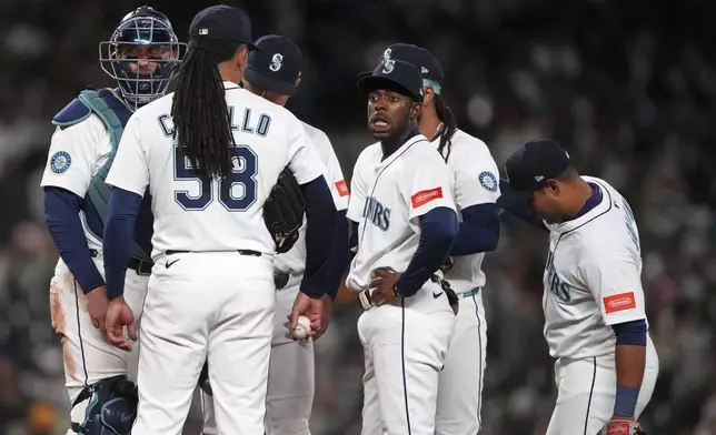 Seattle Mariners starting pitcher Luis Castillo (58) talks on the mound with his infield players, including catcher Mitch Garver, left, and second baseman Ryan Bliss, fourth from left, during the fourth inning of a baseball game against the Houston Astros, Tuesday, April 8, 2025, in Seattle. (AP Photo/Lindsey Wasson)