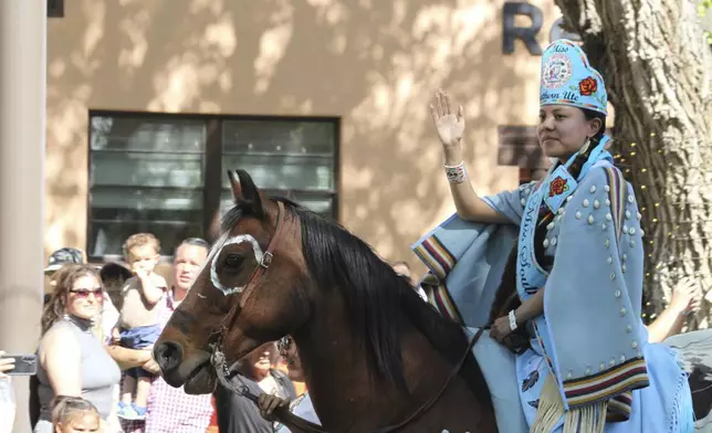 Miss Southern Ute Maleina Carel waves to the crowd as she participates in the horse parade at the annual Gathering of Nations powwow in Albuquerque, New Mexico, on Friday, May 25, 2025 (AP Photo/Susan Montoya Bryan)