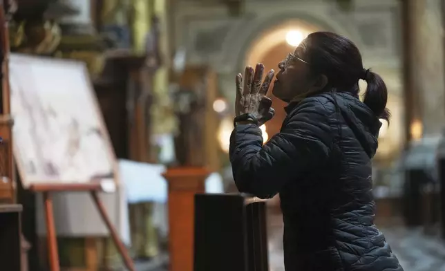 A woman prays at the Basílica de San José de Flores, the church where the late Pope Francis worshipped as a youth, following the Vatican's announcement of his death in Buenos Aires, Argentina, Monday, April 21, 2025. (AP Photo/Rodrigo Abd)