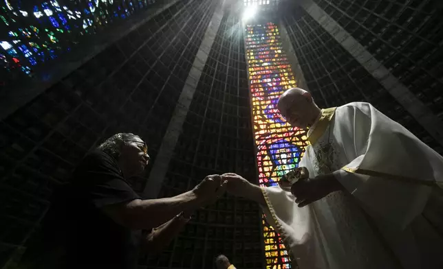 Maria Jose Florenco da Silva receives communion during Mass in honor of the late Pope Francis, following the announcement of his death, in Rio de Janeiro, Monday, April 21, 2025. (AP Photo/Bruna Prado)