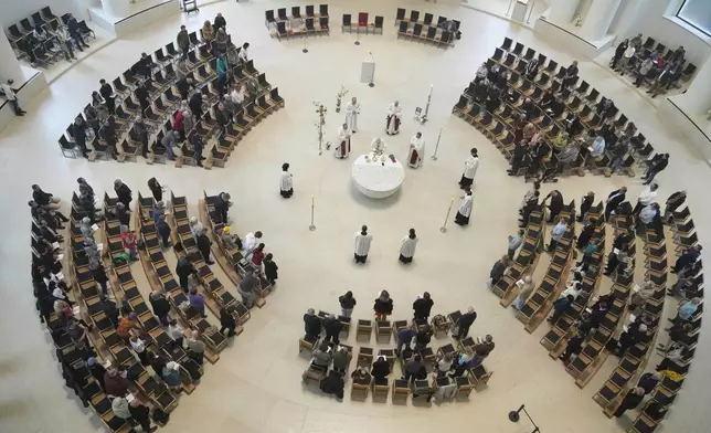 People attend a prayer service in the Saint Hedwig's Cathedral on the day Pope Francis died, in Berlin, Germany, Monday, April 21, 2025. (AP Photo/Ebrahim Noroozi)