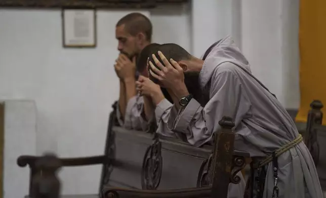 Catholic monks pray at San Francisco Church during a Mass in memory of the late Pope Francis after the news of his death, in Antigua, Guatemala, Monday, April 21, 2025. (AP Photo/Moises Castillo)