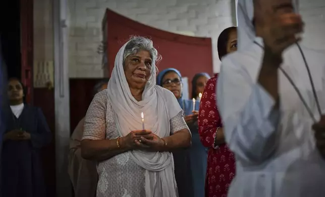 Indian Catholics light candles during a prayer meeting for Pope Francis in Kochi, India, Monday, April 21, 2025 following the announcement of his death by the Vatican. (AP Photo/R S Iyer)