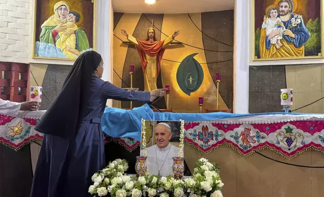 An Indian Catholic nun prepares the altar ahead of a prayer meeting for Pope Francis in Kochi, India, Monday, April 21, 2025. (AP Photo/R S Iyer)