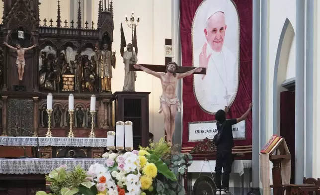 A church official prepare a portrait of Pope Francis ahead of a mass at the Church of Our Lady of the Assumption which was visited by Pope Francis in 2024, in Jakarta, Indonesia, Monday, April 21, 2025. (AP Photo/Achmad Ibrahim)