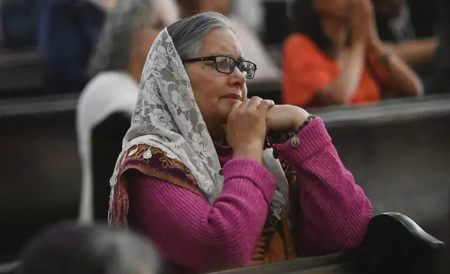 A woman listens to a sermon inside the Sanctuary of Our Lady of Guadalupe Cathedral, as the Catholic Church mourns the death of Pope Francis, Monday, April 21, 2025, in Tijuana, Mexico. (AP Photo/Carlos A. Moreno)