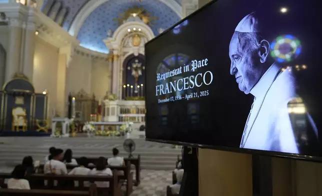 An image of the late Pope Francis is shown as devotees pray at a church in Quezon city, Philippines Monday, April 21, 2025. (AP Photo/Aaron Favila)