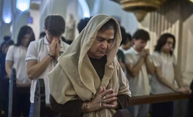 People pray during a Mass in honor of the late Pope Francis at Nuestra Señora de la Asuncion Cathedral in Asuncion, Paraguay, Monday, April 21, 2025. (AP Photo/Jorge Saenz)