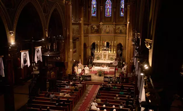 People attend a religious service for the late Pope Francis, following the announcement of his death, at the St. Joseph Cathedral in Bucharest, Romania, Monday, April 21, 2025. (AP Photo/Vadim Ghirda)