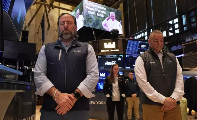 People on the floor of the New York Stock Exchange observe a Moment of Silence for the passing of Pope Francis, Monday, April 21, 2025. (AP Photo/Richard Drew)