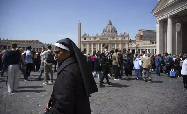 A nun walks in St. Peter's Square at the Vatican after Cardinal Camerlengo Kevin Joseph Farrell announced the death of Pope Francis, Monday, April 21, 2025. (AP Photo/Andrew Medichini)
