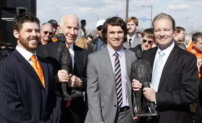 FILE - Following a ceremony honoring the late Philadelphia Flyers' head coach Fred Shero, sculptor Chad Fisher, left, Flyers Chairman Ed Snider Shero's grandson Chris Shero and his son, Pittsburgh Penguins' head coach Ray Shero, hold replicas of the statute of the late coach that was unveiled during a ceremony, Saturday, March 15, 2014, in Philadelphia. (AP Photo/Tom Mihalek, file)