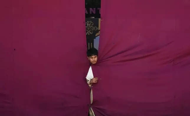 A performer looks out from the stage as they reenact the passion and suffering of Jesus Christ as part of their lenten practice to mark Maundy Thursday, April 17, 2025 in Paete town, Laguna province, Philippines. (AP Photo/Aaron Favila)