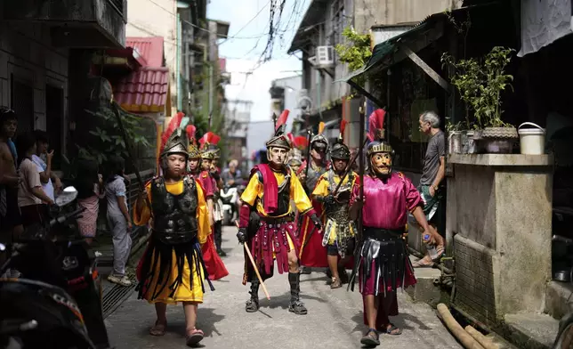 Performers dressed as Roman soldiers walk around town as they reenact the passion and sufferings of Jesus Christ to mark Maundy Thursday April 17, 2025 in Paete town, Laguna province, Philippines. (AP Photo/Aaron Favila)