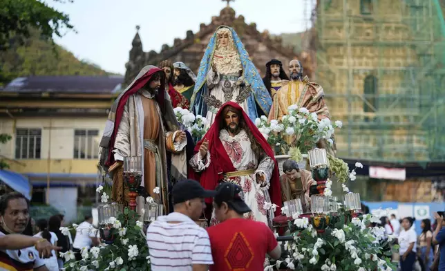 Statues depicting the life and sufferings of Jesus Christ and other saints are pushed by devotees around town during an evening procession as part of their lenten practice to mark Holy Wednesday in Paete, Laguna province, Philippines, April 16, 2025. (AP Photo/Aaron Favila)