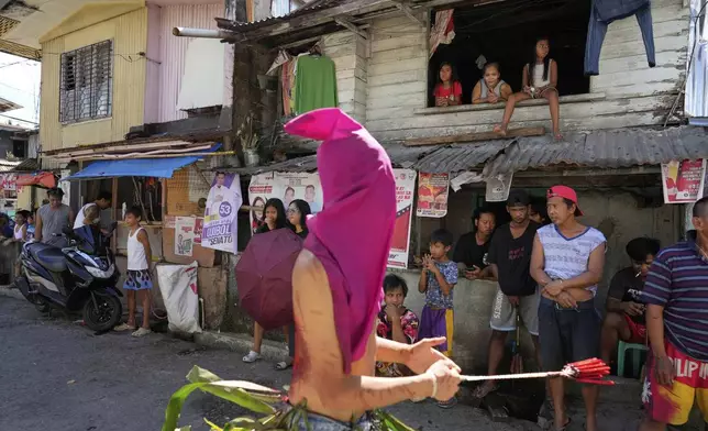Residents watch as penitents flagellate themselves on Good Friday in Kalayaan town, Laguna province, Philippines, April 18, 2025. (AP Photo/Aaron Favila)