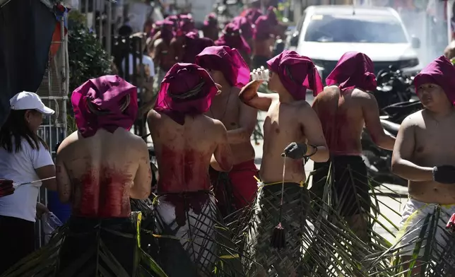 Baby Ragaza distributes boiled eggs and drinking water for penitents who flagellate themselves as part of Holy Week rituals on Good Friday in Kalayaan town, Laguna province, Philippines, April 18, 2025. (AP Photo/Aaron Favila)