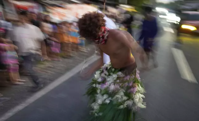 People watch as penitents flagellate themselves on Good Friday in Kalayaan town, Laguna province, Philippines, April 18, 2025. (AP Photo/Aaron Favila)