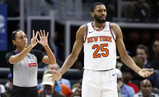 New York Knicks forward Mikal Bridges (25) reacts after being called for a foul by referee Sha'Rae Mitchell, left, during the first half of an NBA basketball game against the Detroit Pistons, Thursday, April 10, 2025, in Detroit. (AP Photo/Duane Burleson)